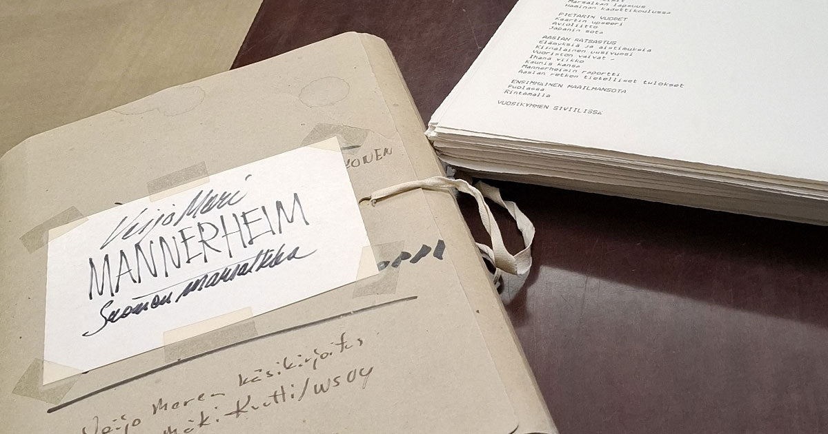 Vanha käsikirjoitus: kannessa käsinkirjoitettuna kirjan nimi "Mannerheim" ja vieressä paperipino, jossa kirjoituskoneella kirjoitettuja arkkeja.