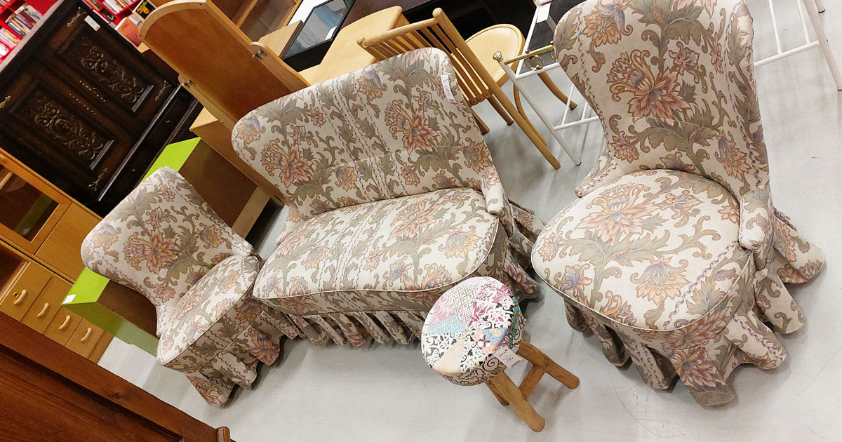 Beige, kukallinen sohvaryhmä myymälässä, taustalla muita huonekaluja
