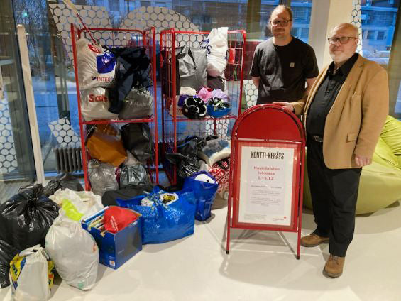 Kaksi henkilöä seisoo lahjoitusrullakoiden vierellä