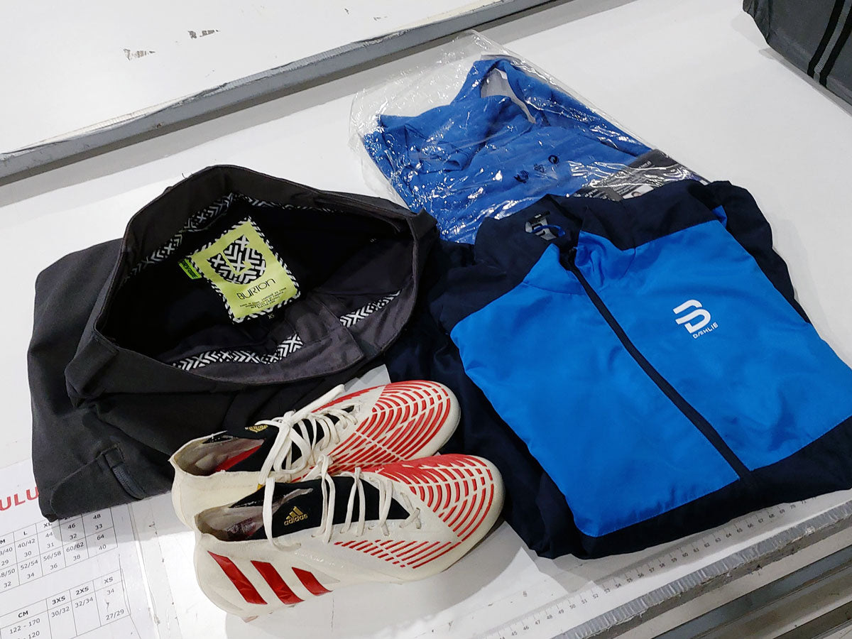 Muutamia vaatteita ja jalkapallokengät pöydällä