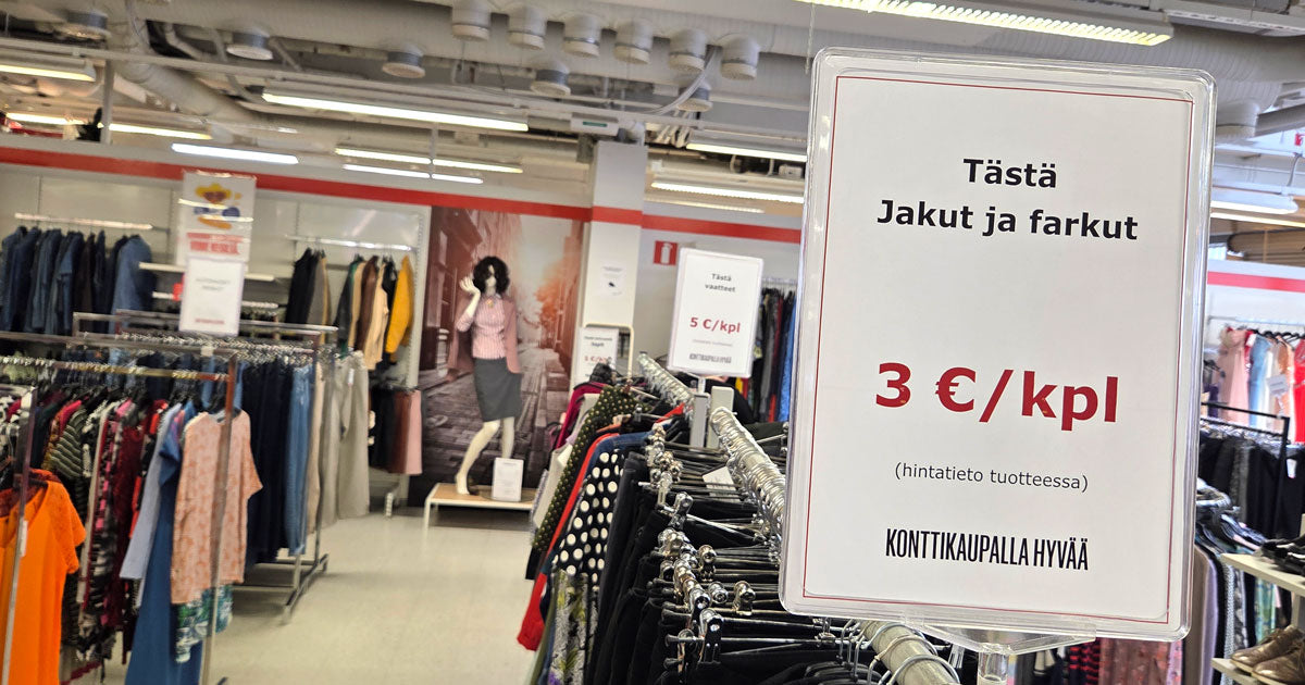 Myymälän vaateosastoa ja etualalla etuhinnoista kertova kyltti. 
