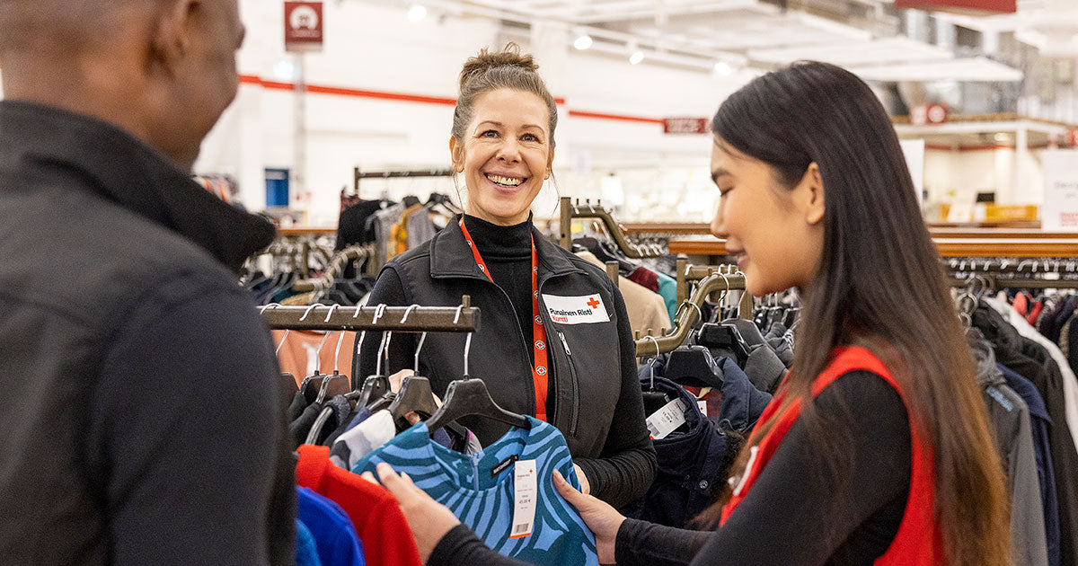Kolme Kontin työntekijää vaaterekkien keskellä.