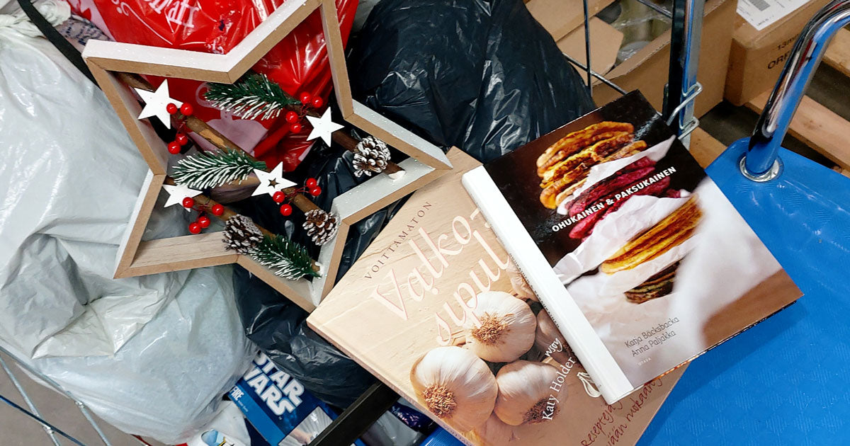 Tähdenmuotoinen joulukoriste ja kaksi ruokakirjaa lahoituskassien päällä.