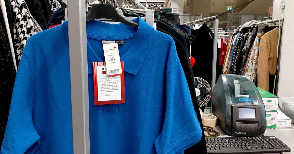 Pikeepaita vaaterekissä, paidan hintalapussa 4 €. Taustalla hinnoittelukone ja muita vaaterekkejä.