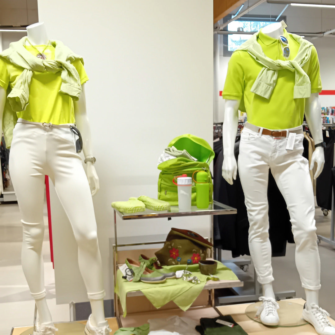 Kahdella mallinukella vihreät paidat ja valkoiset housut.