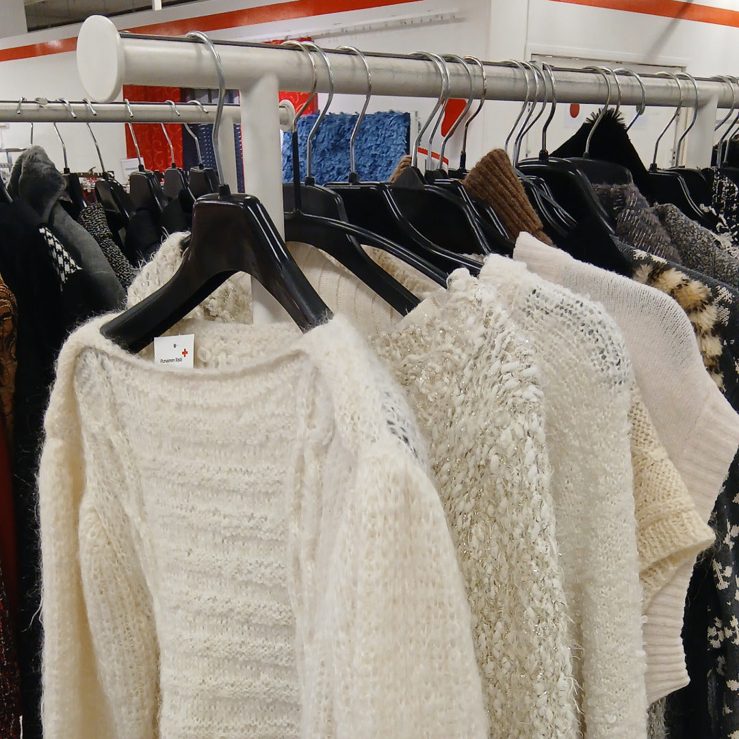 Valkoisia naisten neuleita vaaterekissä.