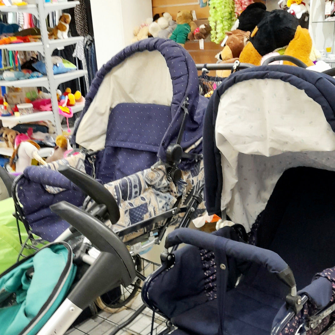 Kahdet lastenrattaat ja taustalla pehmoleluja hyllyissä.