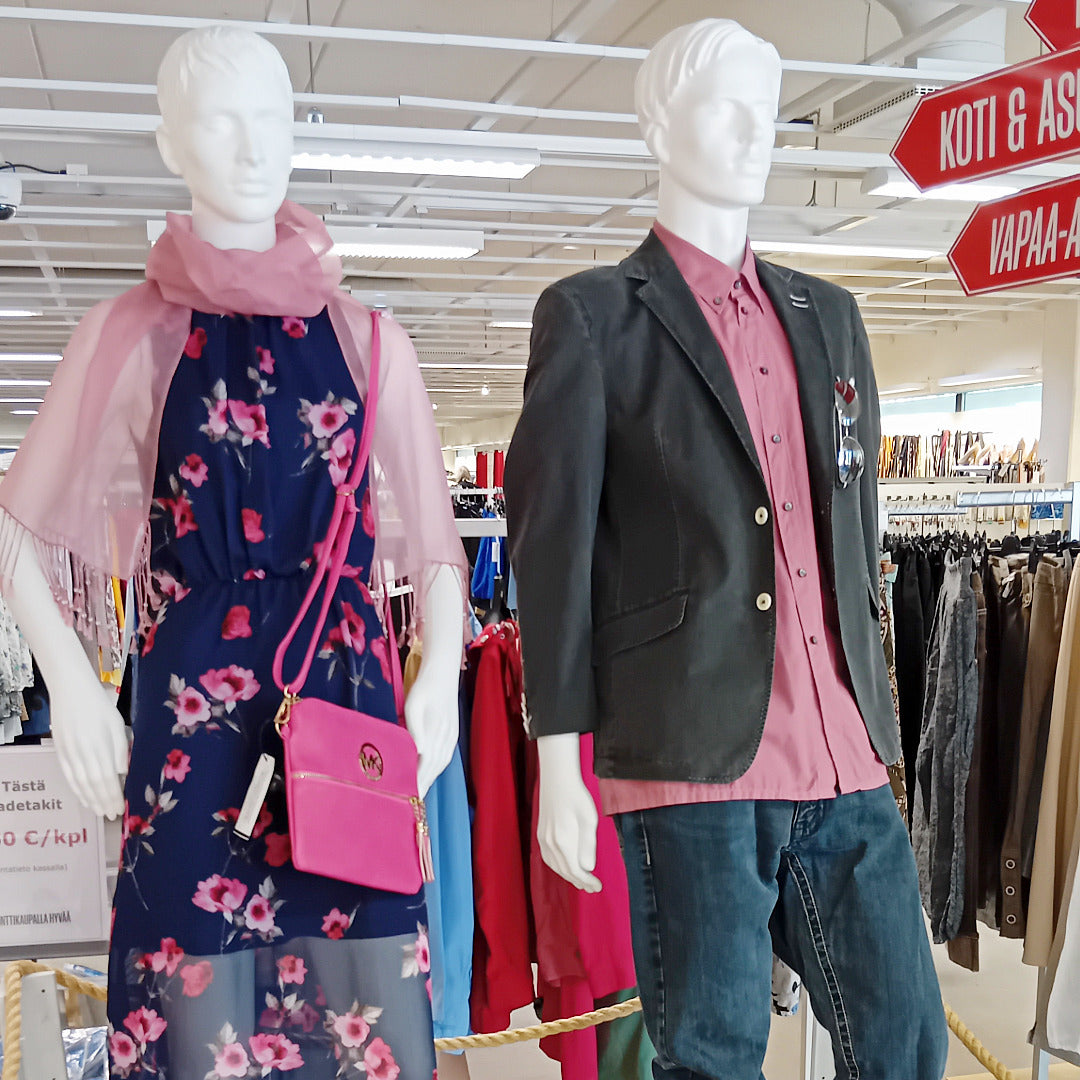 Kaksi mallinukkea, naisen päällä on kesämekko ja miehellä pikkutakki ja farkut.