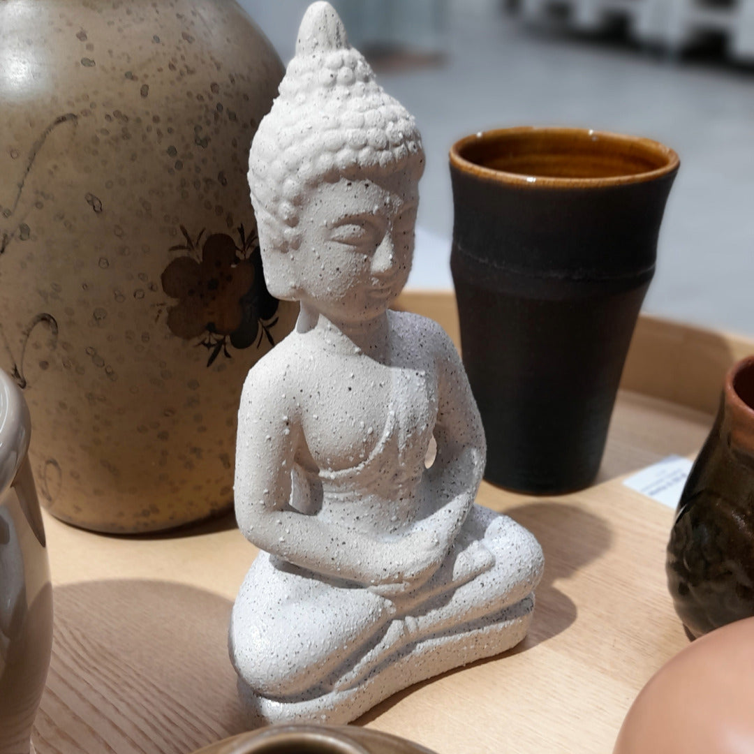 Keraaminen luonnonvalkoinen buddhapatsas.