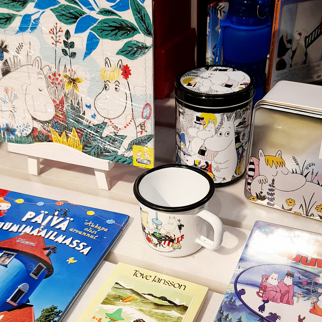 Muumi-tavaroita ja -kirjoja lavapöydällä.