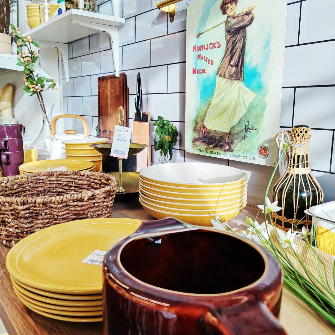 Keltaisia ja ruskeita astioita keittiöesillepanossa.