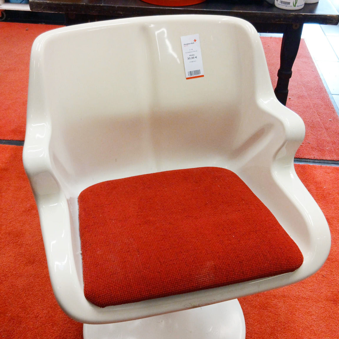 Valkoinen muovinen retrotuoli, jossa on punainen istuinpehmuste.