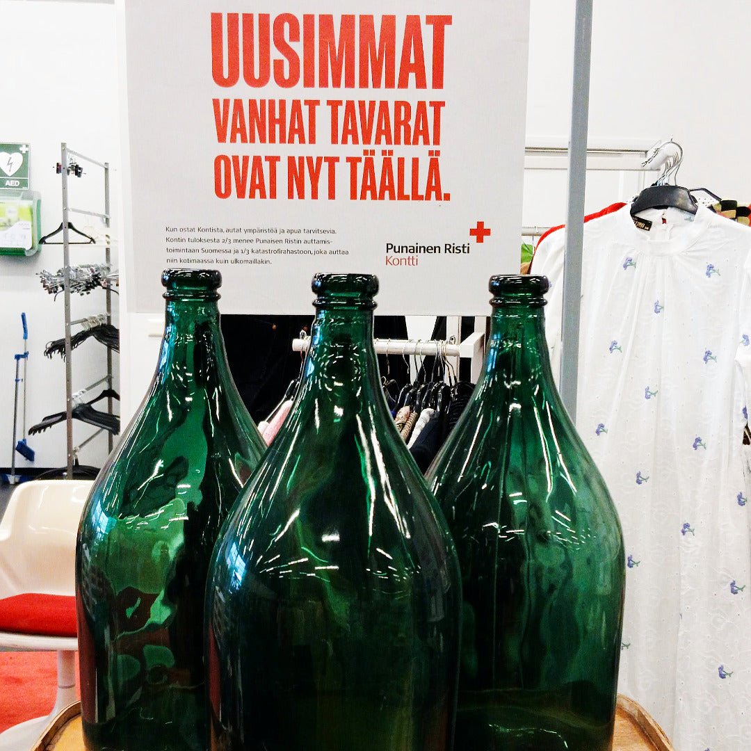 Vihreitä retrolasipulloja ja juliste, jossa teksti: Uusimmat vanhat tavarat ovat nyt täällä.