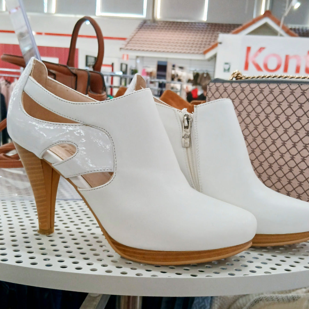 Valkoiset korkokengät reikälevyn päällä.